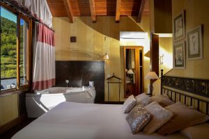 hotel rustico con bañera de hidromasaje en la habitación en Huesca